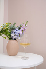 A Beautiful and Elegant Floral Arrangement Decorated with a Wine Glass on a Cozy Table