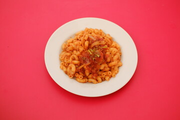 Macaroni with tomato sauce and onions on a white plate.