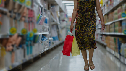 Woman in floral dress walks through colorful aisle, holding vibrant shopping bags image captures joy of shopping and vibrant atmosphere of store