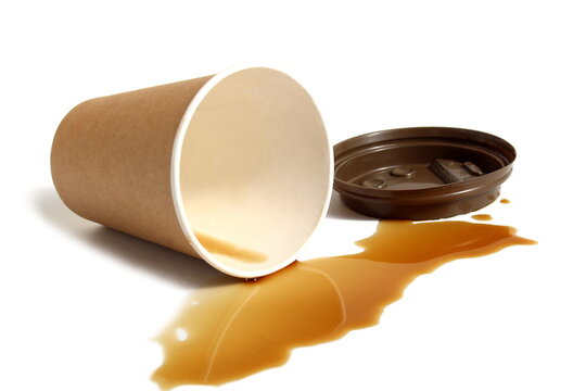 Spilled coffee residue with paper cup lies on white background.