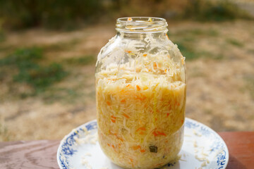 Homemade sauerkraut in a glass jar is a healthy food. Lactic acid fermentation, ripening of grated white cabbage, vegetarian cabbage salad in a jar, close-up