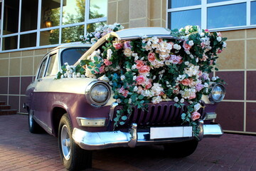 A retro car decorated with bright colors stands on a city street.	