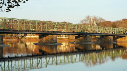 One old iron bridge cross the Delaware river between two old town in autumn