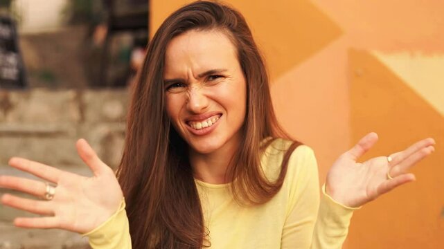 Pretentious brunette woman in knit sweater pointing fingers to camera and next laugh, oh no, wave hands. Girl laughing with a grin sarcasm, sarcastically, ask you no, i not choice you sitting in cafe.