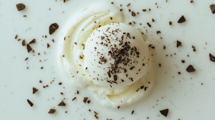 Obraz premium Close-up top view of vanilla ice cream mixed with chocolate flakes, placed against a clean white background, capturing the essence of a delicious stracciatella treat