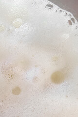 Foam texture extreme close up as background. Milkshake or cappucino foam with bubbles macro shoot. Copy space for text.