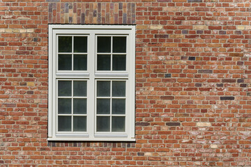  Fenster mit weißem Rahmen an einem historischen Gebäude aus Backstein