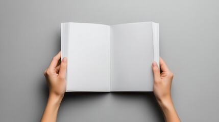woman's hands holding open blank magazine against neutral gray background, perfect for custom content or advertisement mockup