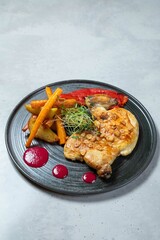 Delicious roasted chicken leg quarter with potatoes and red pepper on plate