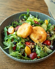 Delicious salad with fried goat cheese, fruits and walnuts on restaurant table