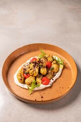 Plate of dumplings served on sour cream with herbs and spices