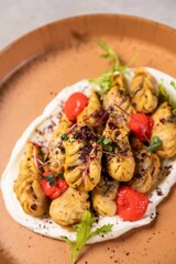 Delicious fried dumplings garnished with microgreens and spices being served on white sauce