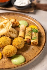 Delicious appetizers served on a plate with dipping sauces