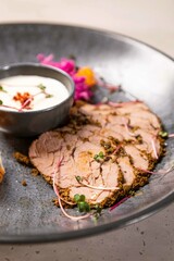Slices of roast beef tenderloin with spices and herbs on plate