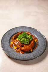 Salmon steak with vegetables and sauce on ceramic plate