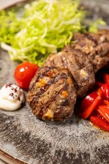 Delicious grilled meatballs served with fresh salad and sauce on plate