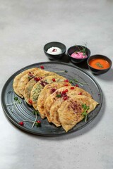Savory flatbreads are served on a plate with dipping sauces