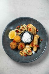 Sharing plate of delicious fried appetizers with dipping sauce