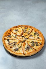 Delicious pizza with chicken and mushrooms lying on table