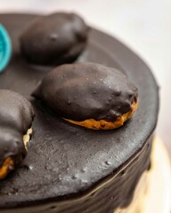 Chocolate cake decorated with chocolate eclairs is waiting for the guests