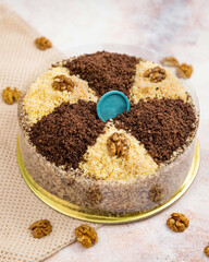 Delicious cake decorated with chocolate and walnuts on white background