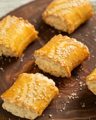 Freshly baked gata pastry with sesame seeds on wooden board