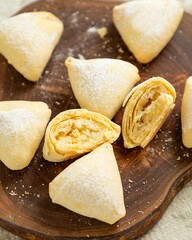 Delicious homemade cookies with cottage cheese filling lying on wooden board