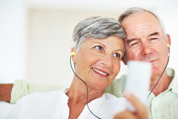 Home, senior couple and music with earphones for listening, hearing and connection for bonding...