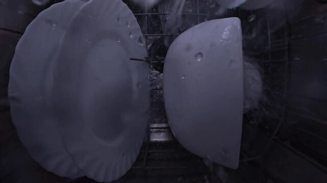 Washing dishes process inside the dishwasher. A powerful stream of water 