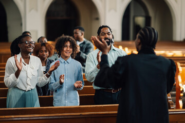 Congregation clapping along with preacher in church