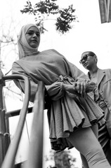 Naklejka premium Urban portrait of female friends posing leaning on a banister.