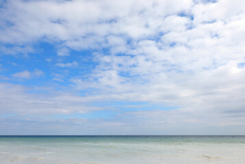 natural landscape with the beautiful sea below and the blue sky above, featuring white cloud perfect for tropical vacations or exotic getaways