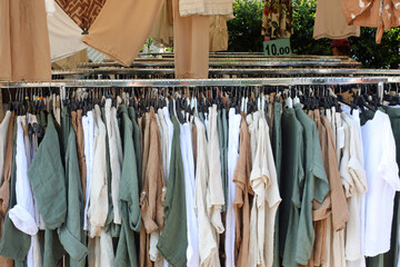 clothes and dresses are hanging on racks for sale at the clothing stall in the market