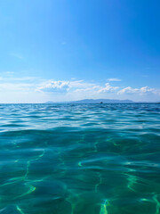 Vertical photo of of sea with half underwater view and cloudy sky as a tourism and summer holiday background 