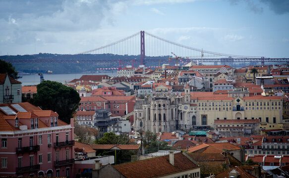 
Lisbon, Portugal. Lisbon urban buildings panorama landscape, view of colorful buildings. blue sky with white clouds. you can see the red bridge in the distance