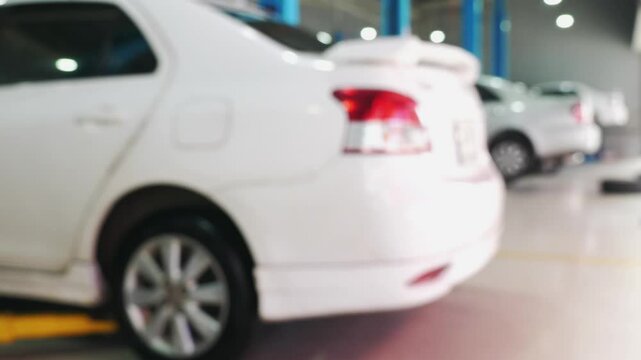 Blurred view of cars in brightly lit, modern auto repair garage, highlighting maintenance services and vehicle care. Auto Repair and Maintenance.