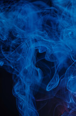 Abstract swirls of blue smoke against a dark background, creating a mysterious and fluid pattern.