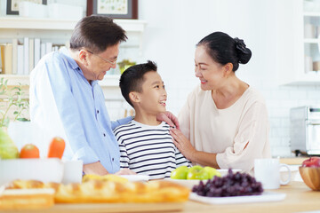 Happy Asian family have a breakfast together in kitchen.