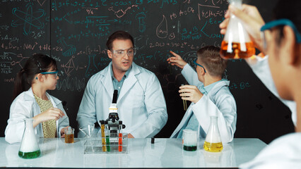 Smart teacher explain about chemical theory while student mixing colored solution or doing...