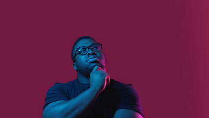 Question puzzled. Choice decision. Uncertain doubtful man with pensive facial expression in neon...