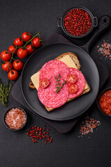 Sandwich with toast, salami slices, cheese and tomatoes, salt and spices