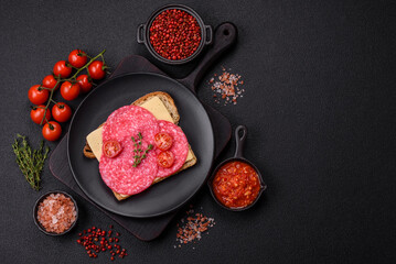 Sandwich with toast, salami slices, cheese and tomatoes, salt and spices
