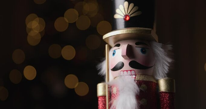 representative Christmas ornament, the wooden Nutcracker rotating for the Christmas spirit, in holiday cheer in front of bokeh lights 