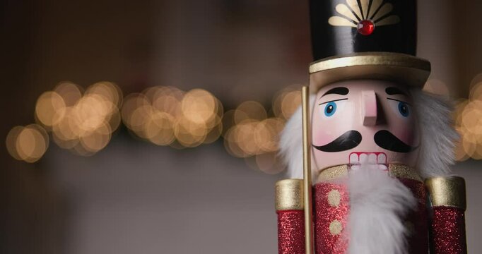 video of festive Nutcracker figurine illuminated by golden bokeh lights, bringing a touch of Christmas magic to any scene
