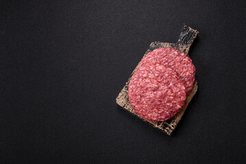 Fresh raw ground beef burger patty with salt and spices