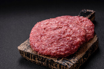 Fresh raw ground beef burger patty with salt and spices