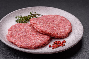 Fresh raw ground beef burger patty with salt and spices