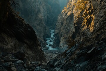 A narrow canyon features a meandering river surrounded by steep rocks, illuminated by gentle sunlight filtering through the cliffs