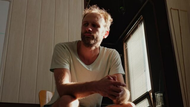 A man, struggling with long-term alcohol addiction, takes a courageous step and attends an Alcoholics Anonymous meeting, seeking support and a path to recovery.