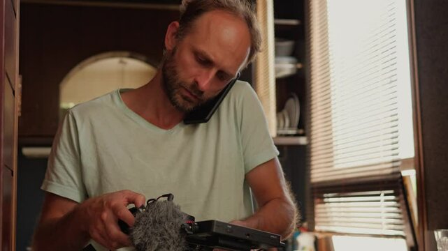 A man pauses filming a YouTube commercial to answer an unexpected phone call from a customer. This scene highlights the interruptions and multitasking often involved in running a business